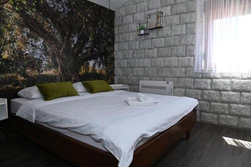 a bedroom with a large bed with towels on it at Apartmani Drijen in Ravno