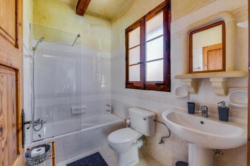 a bathroom with a toilet and a sink and a tub at Haven Farmhouse with Private Pool and Sea Views in Għajn Melel