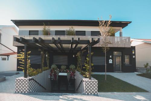 a black house with a pergola with flowers on it at Alma Candida 15 in Ganfei