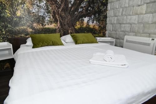 a white bed with a towel on top of it at Apartmani Drijen in Ravno