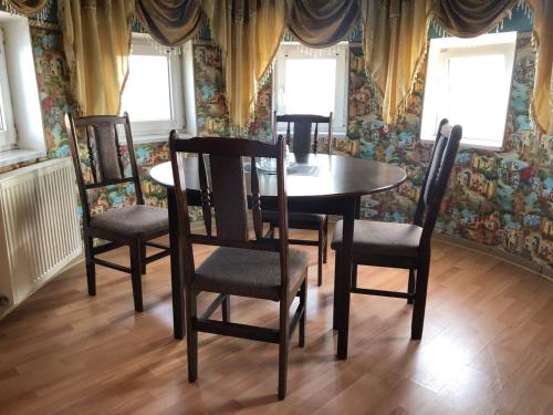 a dining room with a table and four chairs at Готель Оазис in Chernivtsi