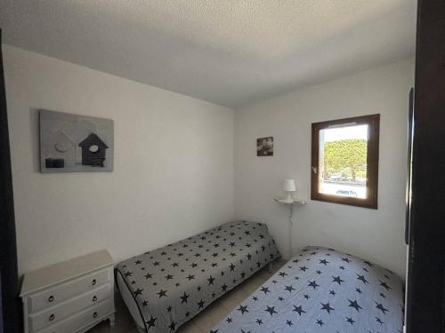 une petite chambre avec un lit et une fenêtre dans l'établissement Appartement climatisé à Argelès-sur-Mer avec Parking - 4 couchages - FR-1-388-52, à Argelès-sur-Mer