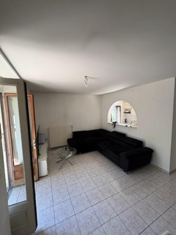 - un salon avec un canapé noir et un miroir dans l'établissement Maison bord de rivière superbe jardin, à Vizille