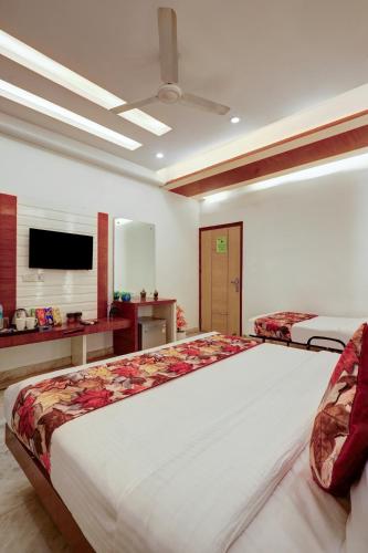 a large bedroom with two beds and a flat screen tv at Hindustan By Backpackers Heaven - Traveller's Choice Award 2025 Best of Best Winning Hotel in New Delhi