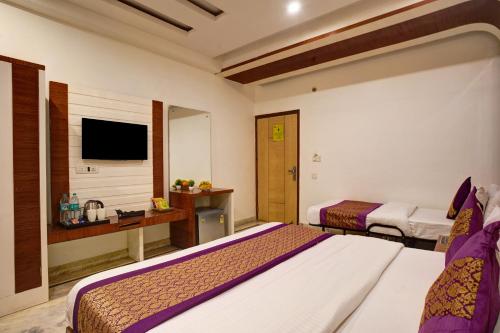 a hotel room with two beds and a television at Hindustan By Backpackers Heaven - Traveller's Choice Award 2025 Best of Best Winning Hotel in New Delhi