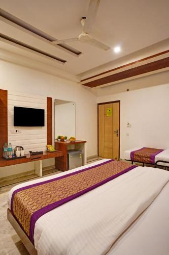 a hotel room with two beds and a television at Hindustan By Backpackers Heaven - Traveller's Choice Award 2025 Best of Best Winning Hotel in New Delhi