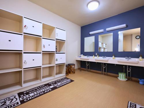a bathroom with two sinks and two mirrors at Oyado Hachibei in Takayama