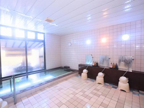 a bathroom with two toilets and a swimming pool at Oyado Hachibei in Takayama
