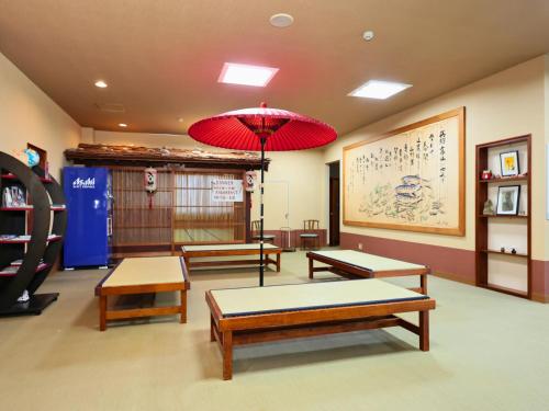 a room with benches and a red umbrella at Oyado Hachibei in Takayama