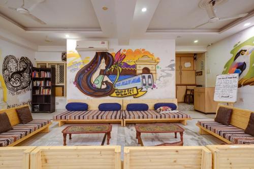 a room with benches and a mural on the wall at Hindustan By Backpackers Heaven - Traveller's Choice Award 2025 Best of Best Winning Hotel in New Delhi