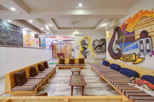 a room with wooden benches and paintings on the walls at Hindustan By Backpackers Heaven - Traveller's Choice Award 2025 Best of Best Winning Hotel in New Delhi