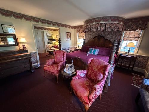 a bedroom with a large bed and two chairs at Asa Ransom House in Clarence