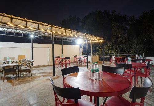 a group of tables and chairs on a patio at night at Hindustan By Backpackers Heaven - Traveller's Choice Award 2025 Best of Best Winning Hotel in New Delhi