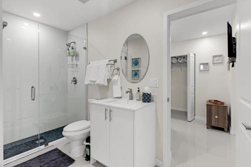 a white bathroom with a toilet and a shower at Bright and Cozy Home in Homestead in Homestead