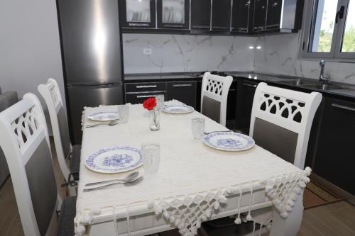 a kitchen with a table with plates and flowers on it at Villa Prendi Mbreshtan in Mbreshtan