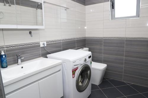 a bathroom with a washing machine and a sink at Villa Prendi Mbreshtan in Mbreshtan