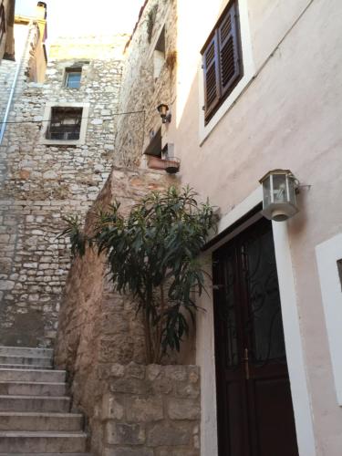 a building with stairs and a door and a plant at The Konoba in Šibenik