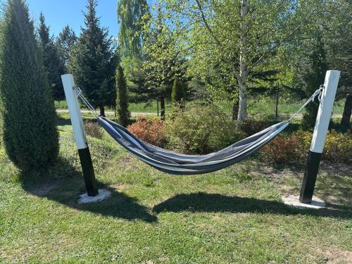 a hammock hanging between two poles in a yard at Domki nad Szelągiem in Kątno