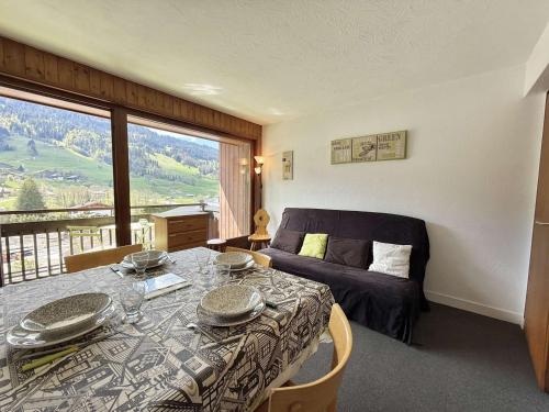 Cette chambre comprend une table, un lit et une fenêtre. dans l'établissement Appartement 2 pièces cabine avec balcon, proche village et pistes - Praz Sur Arly - 5 pers. - FR-1-603-101, à Praz-sur-Arly