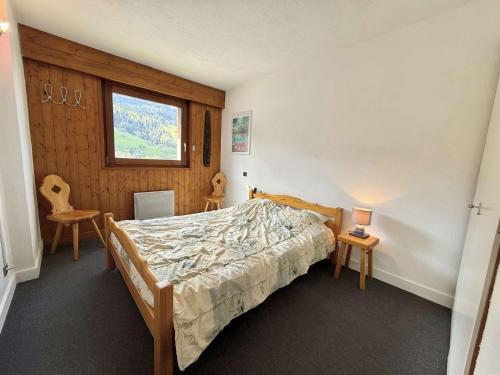 a bedroom with a bed and two chairs and a window at Appartement 2 pièces cabine avec balcon, proche village et pistes - Praz Sur Arly - 5 pers. - FR-1-603-101 in Praz-sur-Arly