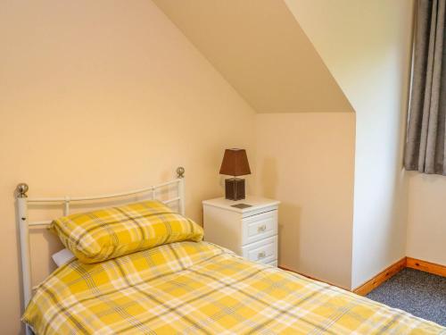 a bedroom with a bed and a lamp on a dresser at Cooinda Flat in Morar