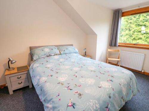 a bedroom with a bed with a blue bedspread with butterflies at Cooinda Flat in Morar