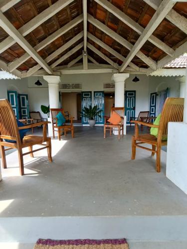 a living room with wooden chairs and a table at Lekham Walauwa in Matale