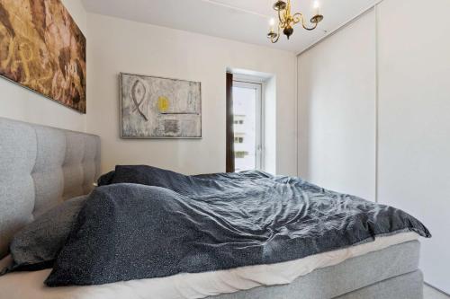 a bedroom with a bed with a blanket on it at Nimastay - Modern Family Townhouse in Charming Risskov in Risskov