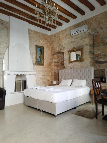 a bedroom with a large white bed in a stone wall at Tsopela Boutique Hotel in Skiathos Town