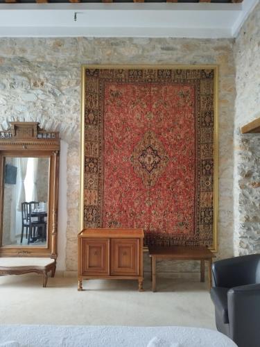 a large red rug on a wall with a table and a mirror at Tsopela Boutique Hotel in Skiathos Town