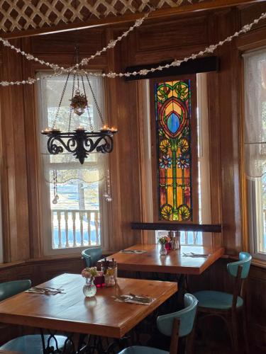 a dining room with two tables and a stained glass window at Albergo Allegria Hotel & Breakfast Restaurant in Windham