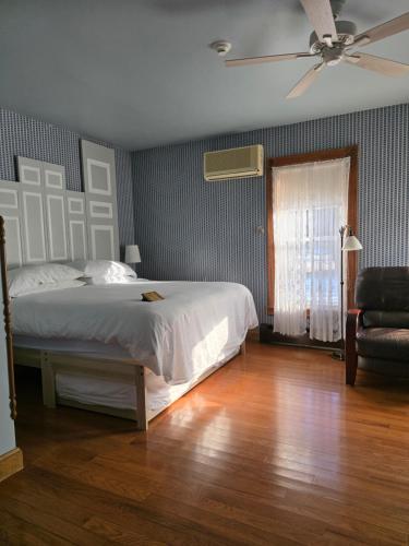 a bedroom with a bed and a ceiling fan at Albergo Allegria Hotel & Breakfast Restaurant in Windham