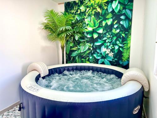 a blue and white tub in a room with a plant at Duplex Le Chant des Oiseaux in Abbeville