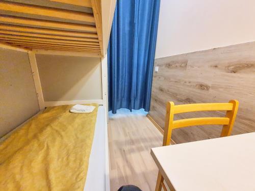 a room with a table and a chair in a room at Tokyo Vibes - Private Sleeping Pods Hostel, Self check-in in Vilnius