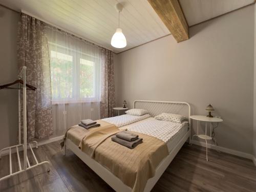 a bedroom with a bed with towels on it at Na skraju lasu in Kolonia