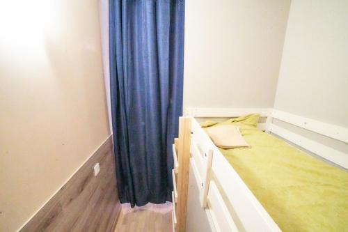 a room with two bunk beds with blue curtains at Tokyo Vibes - Private Sleeping Pods Hostel, Self check-in in Vilnius