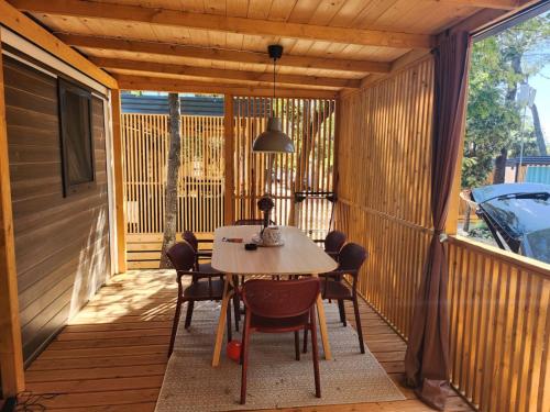 ビオグラード・ナ・モルにあるMobile home Nikaのテーブルと椅子が置かれた網戸付きのポーチ
