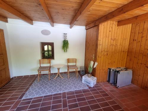 a room with a table and two chairs and a refrigerator at Ferienzimmer Kefeder in Lochenhaus