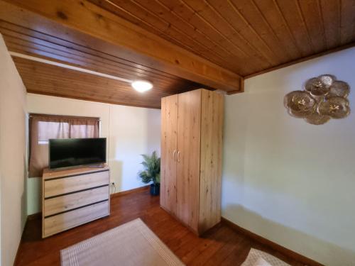 a living room with a television and a wooden ceiling at Ferienzimmer Kefeder in Lochenhaus