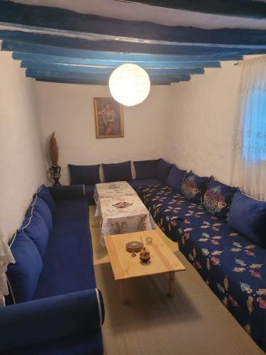 a living room with a blue couch and a table at Casa de campo in Al Hoceïma