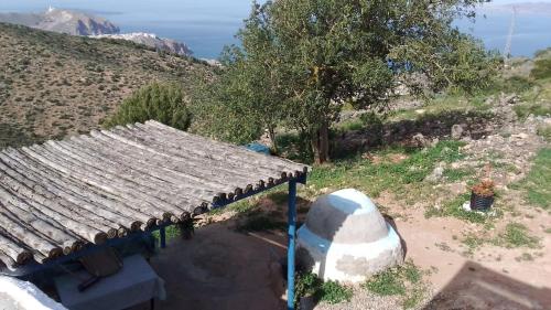 a small house with a roof on top of a hill at Casa de campo in Al Hoceïma