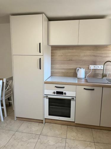 バンスカー・シュチャヴニツァにあるApartmán pod Kalváriou II - rodinný domの白いキャビネットと白い冷蔵庫のあるキッチン