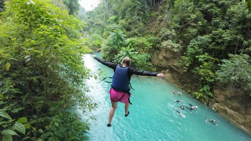 a woman jumping into a river in the jungle at Lymen's Apartment in Cordova