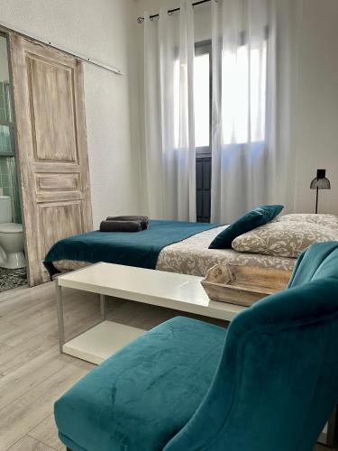 a room with two beds and a couch and a table at Studio3 proche Quai Rouget in LʼIsle-sur-la-Sorgue