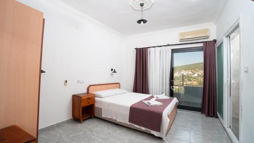 a bedroom with a bed and a large window at Hotel Sema in Patara
