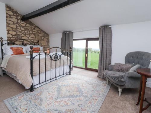 ein Schlafzimmer mit einem Bett und einem Stuhl und einem Fenster in der Unterkunft Stoneycross Cottage in Preston