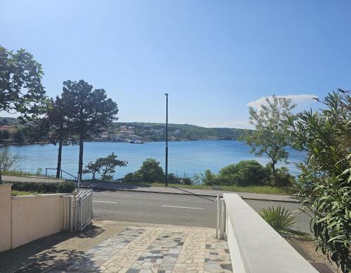 a road with a view of a body of water at Seafront apartment with balcony-50 m from the sea in Šilo