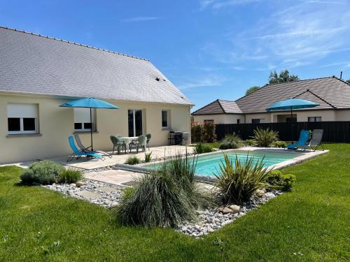 une cour arrière avec une piscine et une maison dans l'établissement Maison les coquelicots, à Garennes-sur-Eure