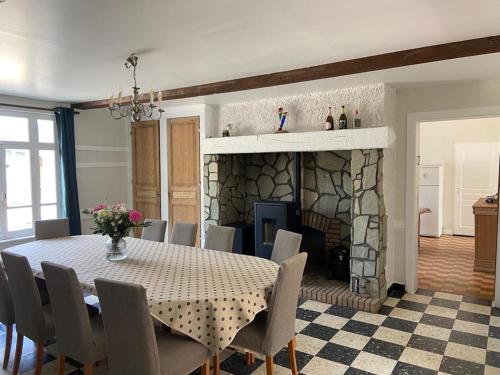 une salle à manger avec une table et une cheminée dans l'établissement Le Domaine du Tronquoi., à Vironchaux