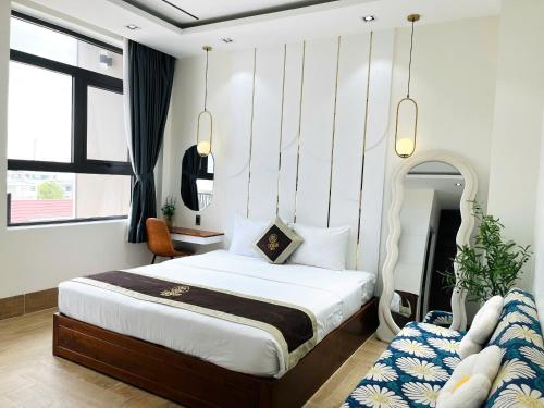 a bedroom with a large bed and a mirror at Lucasta Hotel in Can Tho